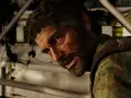 Joel, con heridas en el rostro, mira fijamente. Detrás de él, una estructura de piedra cubierta de hiedra. ¿Esconde algo, como una caja fuerte de The Last of Us 1?