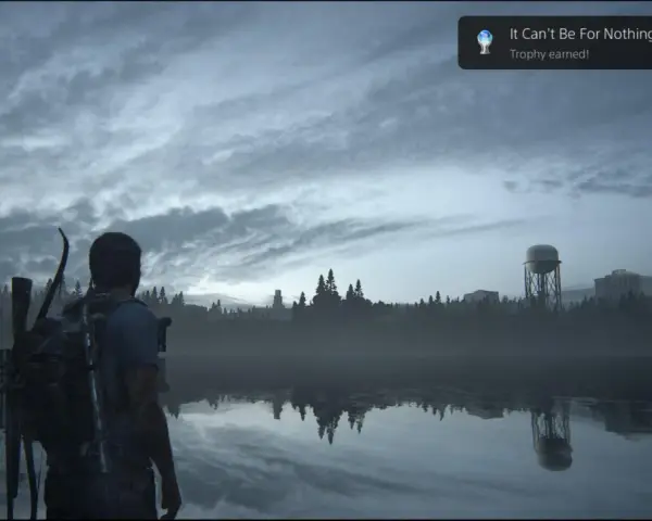 Joel mira un lago tranquilo, con un cartel de "Platino The Last of Us Parte 1" flotando.